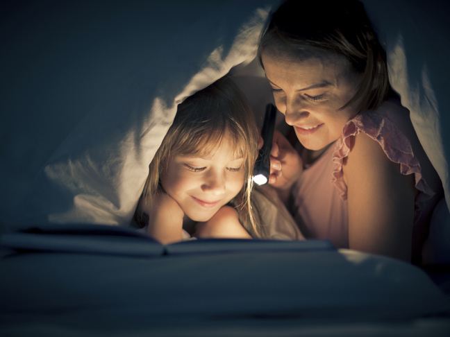 Bedtime reading flashlight mom daughter
