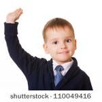 Stock photo small schoolboy raises his hand 